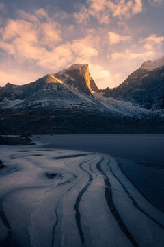 frozen lake in front of mountain in sunset