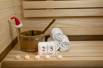 Sauna. Towels, candles are burning and a calendar for December 25, a wooden bucket with a spoon,...