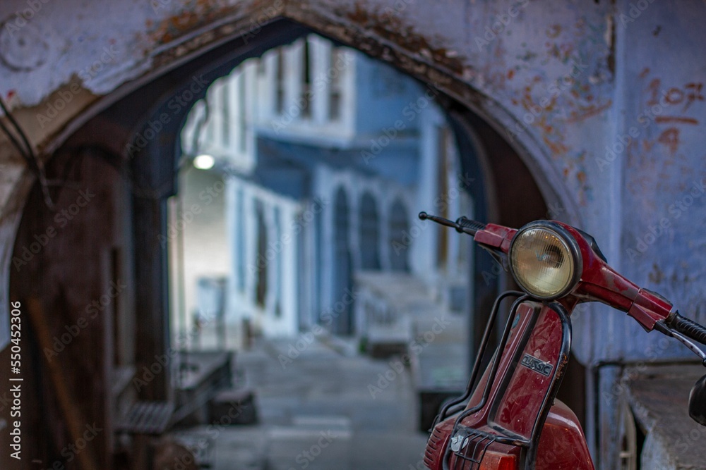 Wall mural Vintage red scooter with old traditional building in the blurred background - Wall murals