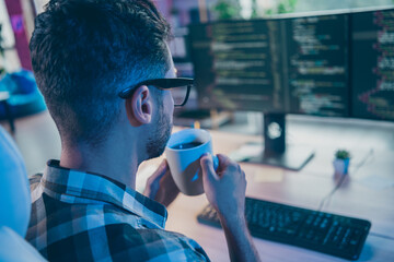 Rear portrait of smart intelligent hacker sit chair arms hold tea mug look pc screen workstation...