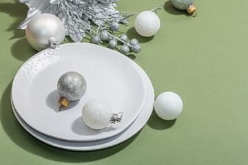 Christmas table setting with ceramic plates, traditional decor on Savannah Green color background