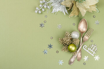 Obraz na płótnie Canvas Christmas table setting with ceramic plates, traditional decor on Savannah Green color background