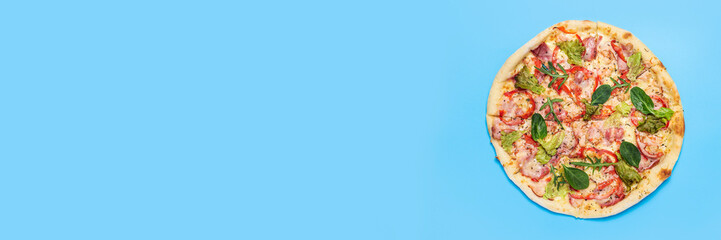 whole pizza fresh hot on a blue background. Top view, flat lay. Banner