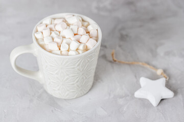 Cup of hot cocoa and marshmallows, gray background