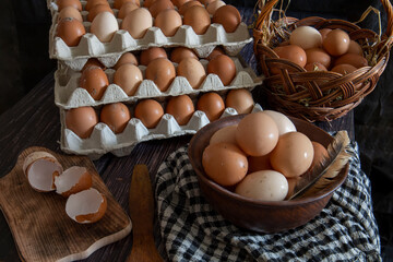 Chicken eggs in a clay plate and trays on the table