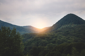 Beautiful sunset in the mountains landscape, green slopes of the mountains