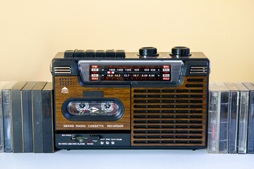 Radiomagnetofon w stylu lat 80-tych i 90-tych, obok kasety magnetofonowe