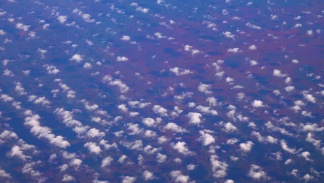 Cirrocumulus, granular cloudlets. Fleece clouds under the wing of an airplane. The flight takes place at an altitude of 11,000 meters