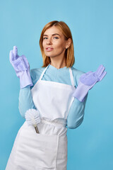 woman in rubber gloves and cleaner apron holding toilet brush
