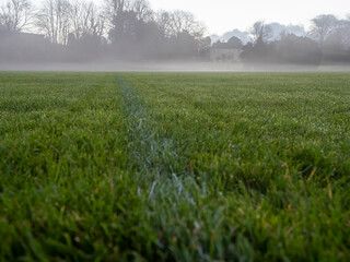 Obraz premium Irish National sport ground wit tall goal posts for camogie, hurling, rugby, Gaelic football at dusk and low fog over the ground. Calm and peaceful mood. Sport activity concept.