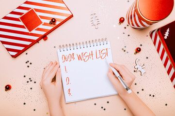 Wish list 2023 writting in empty notebook. Reusable Red and white boxes for presents in different...