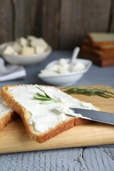 Fototapeta na wymiar Delicious toast with tofu cream cheese and rosemary on grey wooden table, closeup