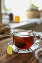 Tea bag in glass cup on wooden table indoors