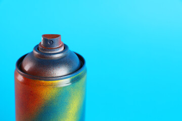 Used can of spray paint on light blue background, closeup. Space for text
