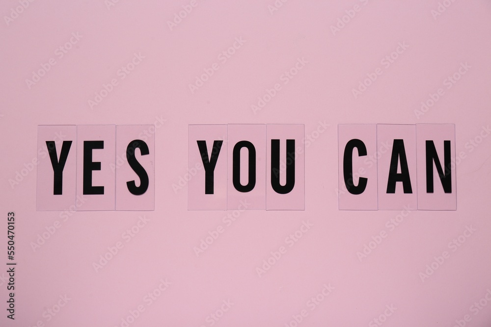Wall mural phrase yes you can of plastic letters on pink background, top view. motivational quote