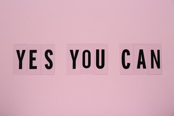 Phrase Yes You Can of plastic letters on pink background, top view. Motivational quote - obrazy, fototapety, plakaty