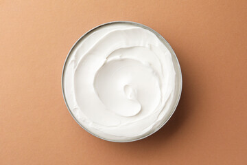 Jar of face cream on beige background, top view