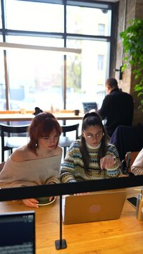 Students study together, learn in teamwork do homework in a coffee shop