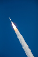 A rocket blasting off and soaring into space in the sky going upward after lifting off from launch...