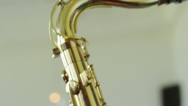 Close up shot of jazzman playing saxophone during rehearsal with band in studio