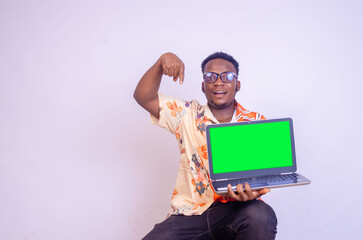 Excited african american man in casual black t-shirt isolated on white background. People lifestyle concept. Mock up copy space. Hold laptop pc computer with blank empty screen