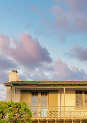 Vertical Puffy clouds at sunset Low angle view of a balcony with two double doors and shutters a