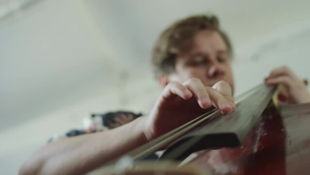 Low angle view of jazzman playing double bass music on rehearsal