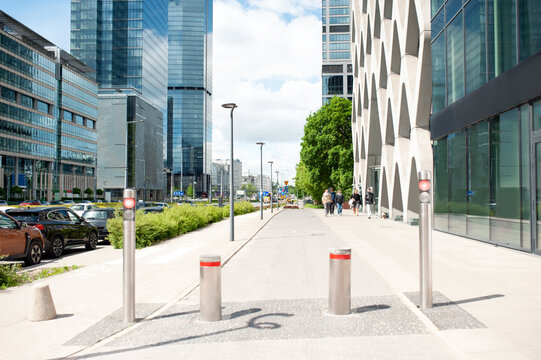 Beautiful bollards near buildings with many windows on cloudy day in city