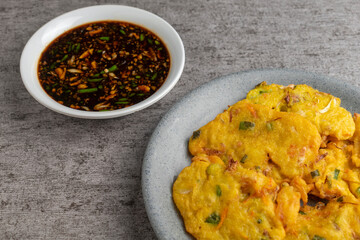 bakwan is vegetable fritter from Indonesia. made from mixed vegetable and flour fried in cooking oil. served with dark spicy sauce