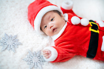 クリスマスにサンタの服を着る生後２か月の赤ちゃん