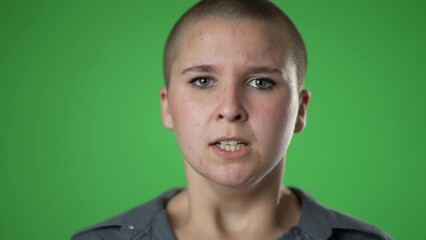 Portrait of angry frustrated despair upset portrait of gender fluid non binary young woman 20s closeup slow motion isolated on green screen background