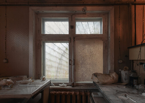 Old and dusty window with bars in an abandoned house