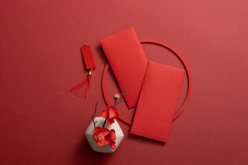 Top view of lucky envelopes and decorative items for the Chinese lunar new year on a red background. Space for text