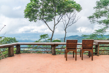 Fototapeta na wymiar wood bar and chair with mountain hill background