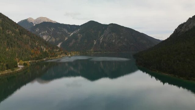 Aerial view of Lake Plansee in Austrian Apls mountains in autumn, water reflections. European Alps. Famous landmark, travel destination. Austria.