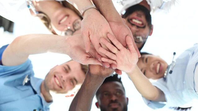 Low Angle View Of Doctor Stacking Hands Together In Hospital