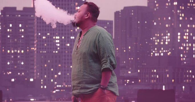 Portrait of a young pacific islander businessman in casual clothes or hipster looking at the camera. Plus size entrepreneur or manager posing, cityy in the night in background. 