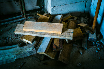 Different building materials lie on the floor in an unfinished house close-up. Construction waste. Wooden trimmings in cool colors