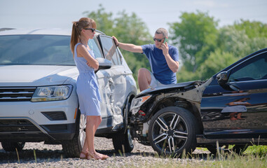 Drivers of smashed vehicles talking on cellphone calling for help in car crash accident on street...