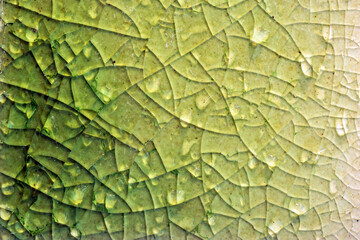 Close up to background and texture of stretch marks cracked on emerald green glazed tile. Scratches...