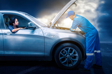 Mechanic check a broken car on road with customer