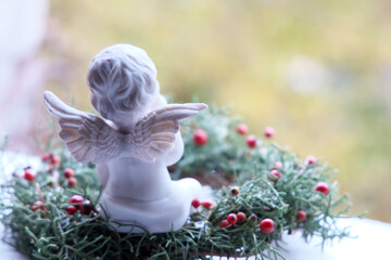 天使の後ろ姿と赤い実のクリスマスリース横向き
