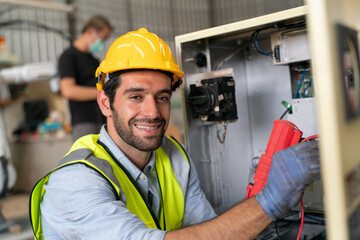 Robotics engineer working on maintenance of modern robotic arm in factory warehouse