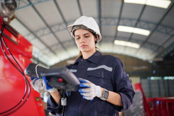 Robotics engineer working on maintenance of modern robotic arm in factory warehouse