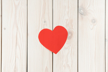 Small red handmade paper heart on white wood plank background. Donation, charity, open hearts of volunteers day. Healthcare and medicine aid, relief and humanitarian help. Flat lay, copy space