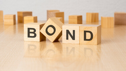 four wooden blocks with text BOND on table. copy space. white background.