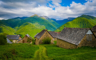 Fototapeta na wymiar Traditional houses in the village of Antras with view on the mountains of the French Pyrenees