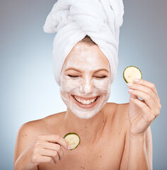 Laughing woman, skincare face mask and cucumber on studio background in acne dermatology,...