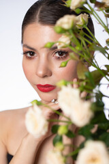 Fototapeta na wymiar Beautiful girl with small spray roses. Beautiful white girl with flowers. Woman with bright makeup.