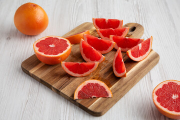 Organic Red Ruby Grapefruit on a Wooden Board, side view.